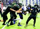 Four PSJA Memorial Wolverines’ defensive players tackle Edinburg Vela ballcarrier after a short gain on the ground.